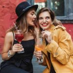 Young attractive woman in black dress and hat thoughtfully talki